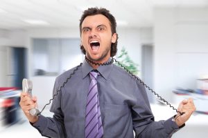 Angry office worker choking himself with his phone cord